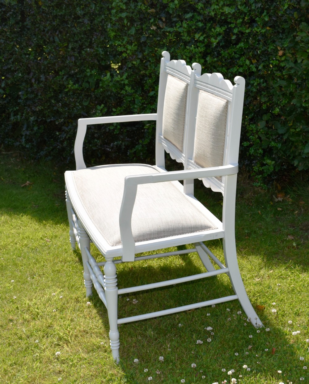 A white painted Edwardian two-seater bench featuring turned legs and neutral linen upholstered seat and back panels. View VIII