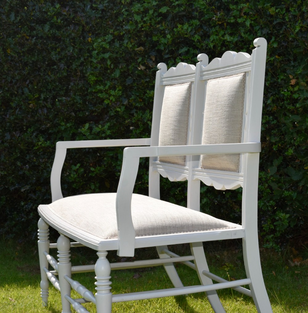 A white painted Edwardian two-seater bench featuring turned legs and neutral linen upholstered seat and back panels. View XI