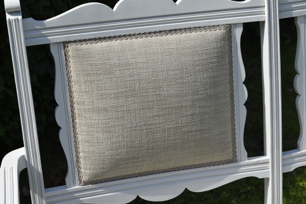 A white painted Edwardian two-seater bench featuring turned legs and neutral linen upholstered seat and back panels. View XVI