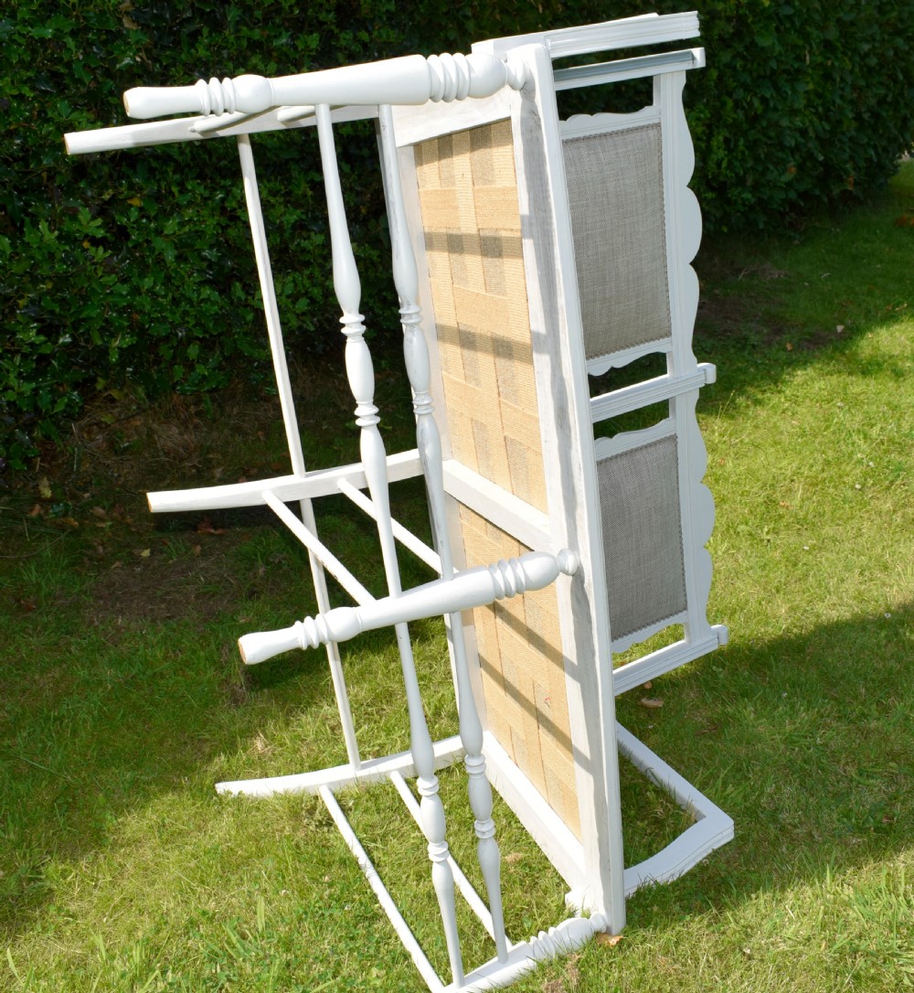 A white painted Edwardian two-seater bench featuring turned legs and neutral linen upholstered seat and back panels. View XXII