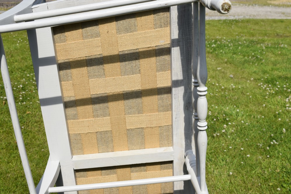 A white painted Edwardian two-seater bench featuring turned legs and neutral linen upholstered seat and back panels. View XXIII