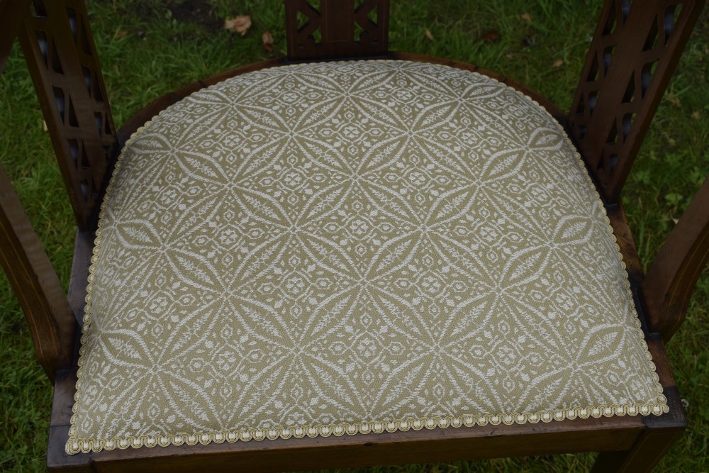 An Edwardian mahogany tub armchair featuring satinwood inlay, pierced lattice back splats, curved arms, and a light pattern-upholstered seat. View IX