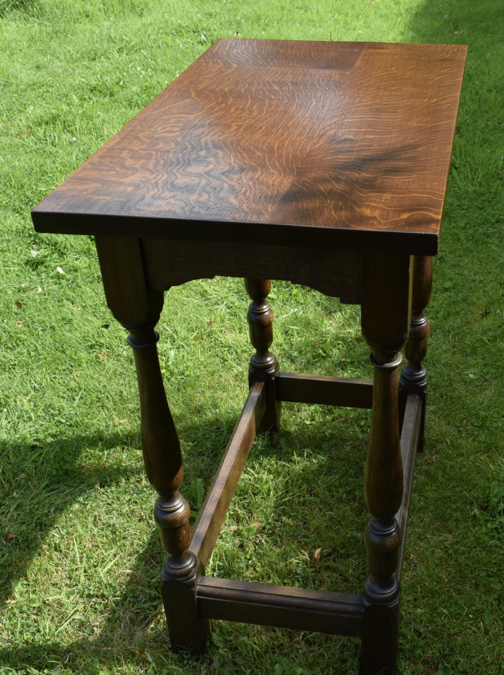 A tall rectangular dark oak side table featuring turned legs, a shaped apron, and lower perimeter box stretchers. View VIII