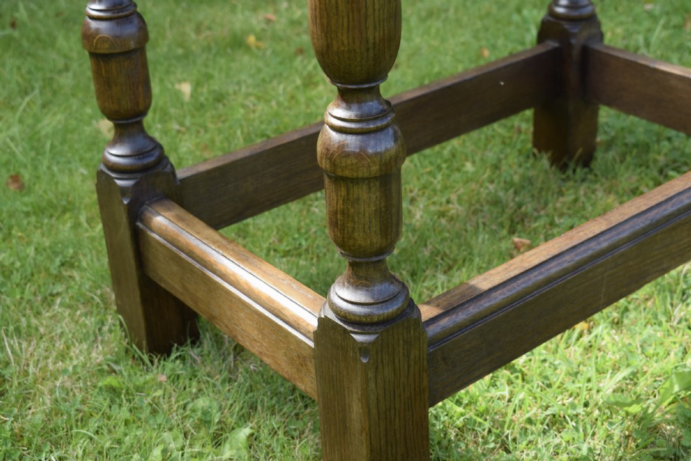 A tall rectangular dark oak side table featuring turned legs, a shaped apron, and lower perimeter box stretchers. View XIII