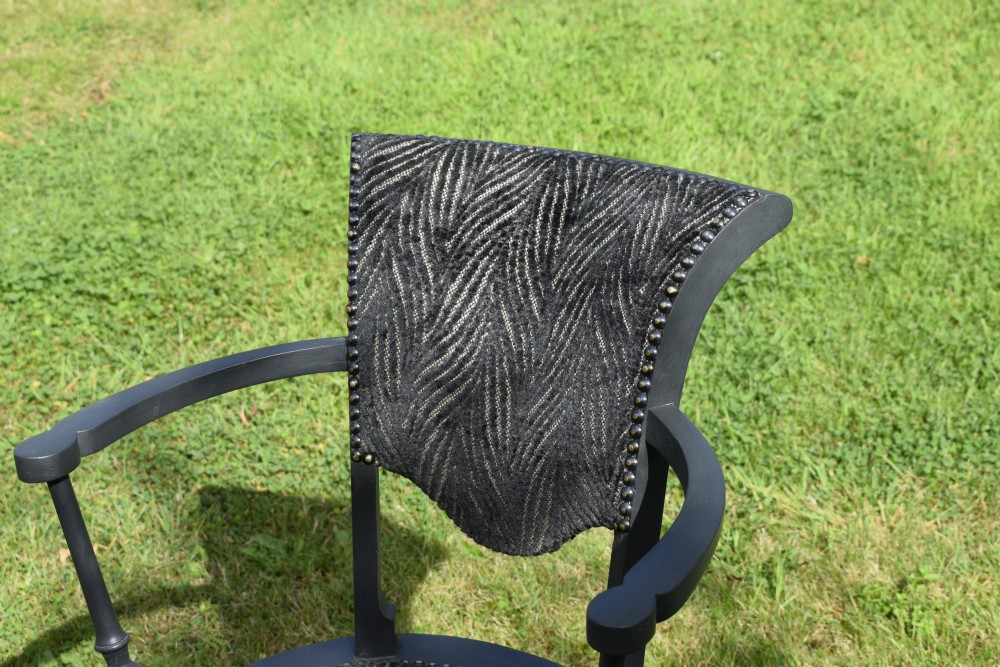 A dark grey painted Arts and Crafts style elbow chair featuring textured patterned fabric upholstery on the seat and curved backrest. View VII