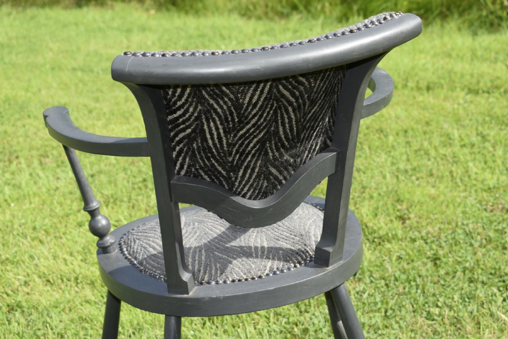 A dark grey painted Arts and Crafts style elbow chair featuring textured patterned fabric upholstery on the seat and curved backrest. View XIV