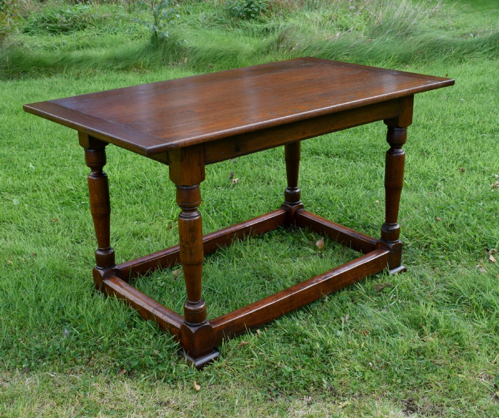 A rectangular dark oak refectory dining table featuring turned legs and a low perimeter stretcher base. View VIII