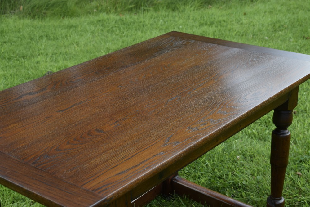 A rectangular dark oak refectory dining table featuring turned legs and a low perimeter stretcher base. View XIV