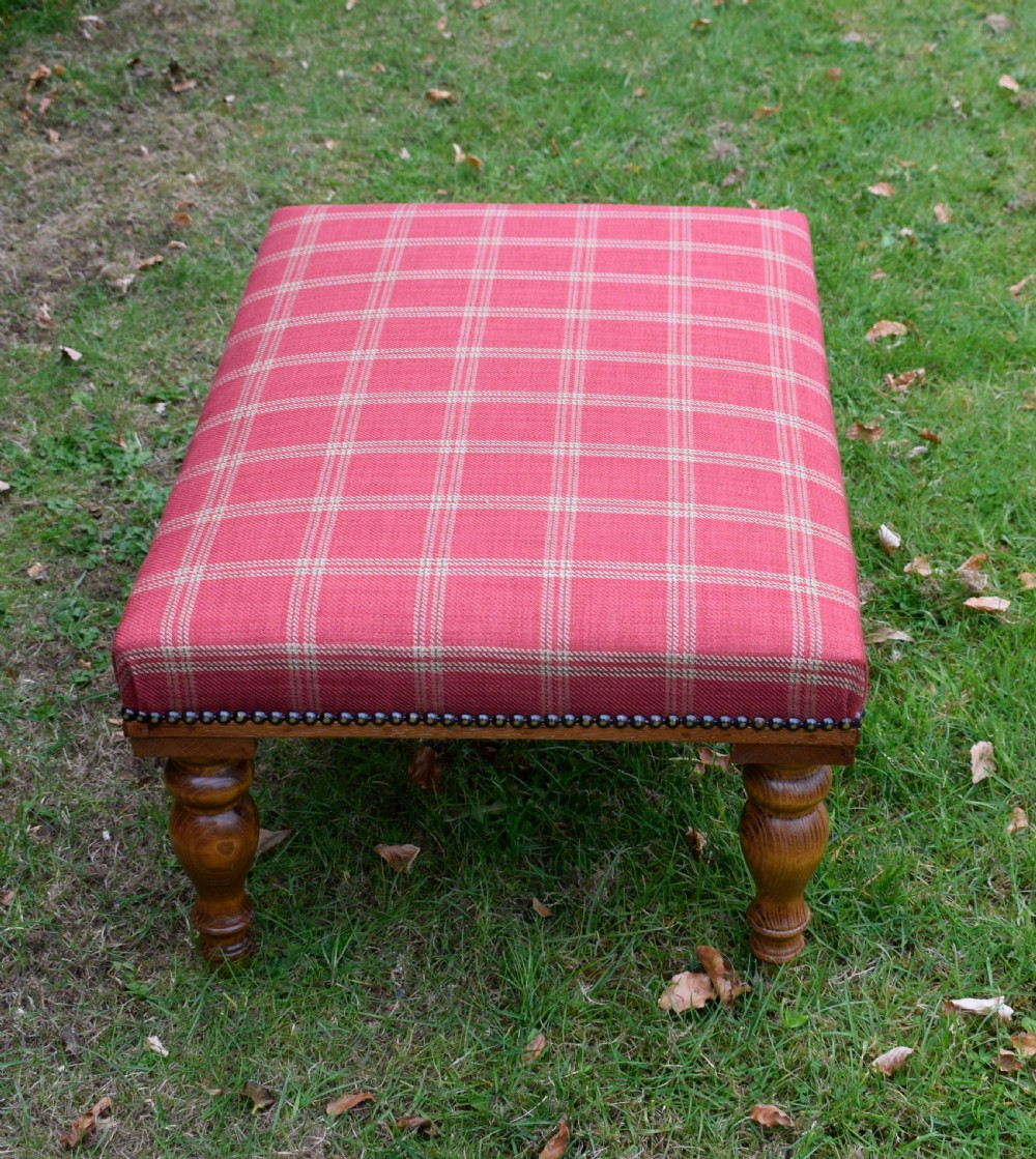 A large rectangular oak centre stool upholstered in red tartan fabric with turned legs and brass stud trimming. View III