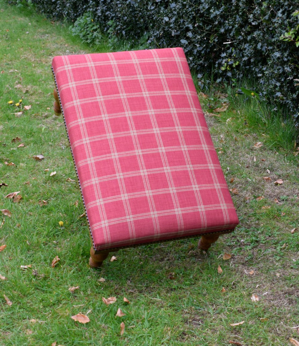 A large rectangular oak centre stool upholstered in red tartan fabric with turned legs and brass stud trimming. View X