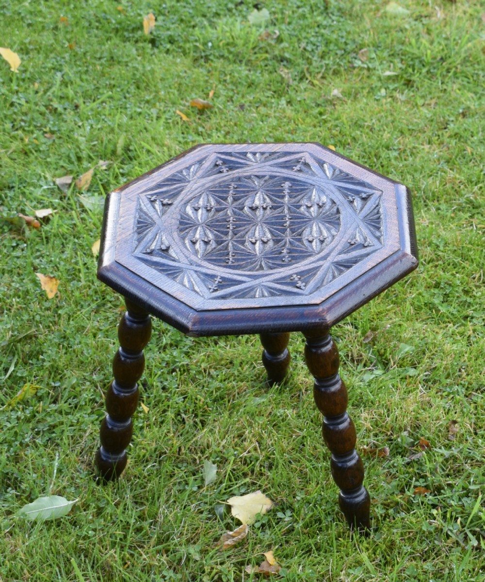 A dark stained wooden side table featuring an octagonal carved geometric top supported by three bobbin-turned legs. View IV