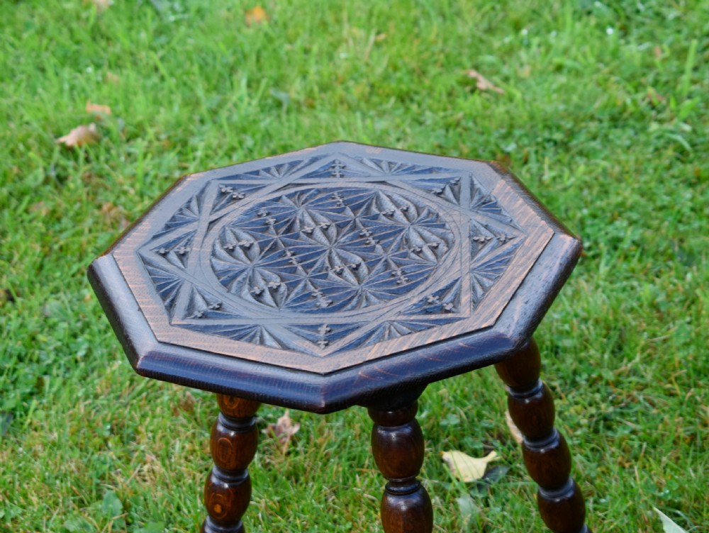 A dark stained wooden side table featuring an octagonal carved geometric top supported by three bobbin-turned legs. View VIII