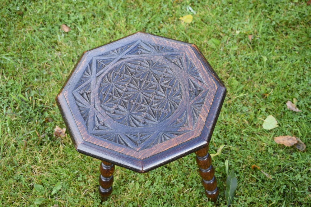 A dark stained wooden side table featuring an octagonal carved geometric top supported by three bobbin-turned legs. View XIII