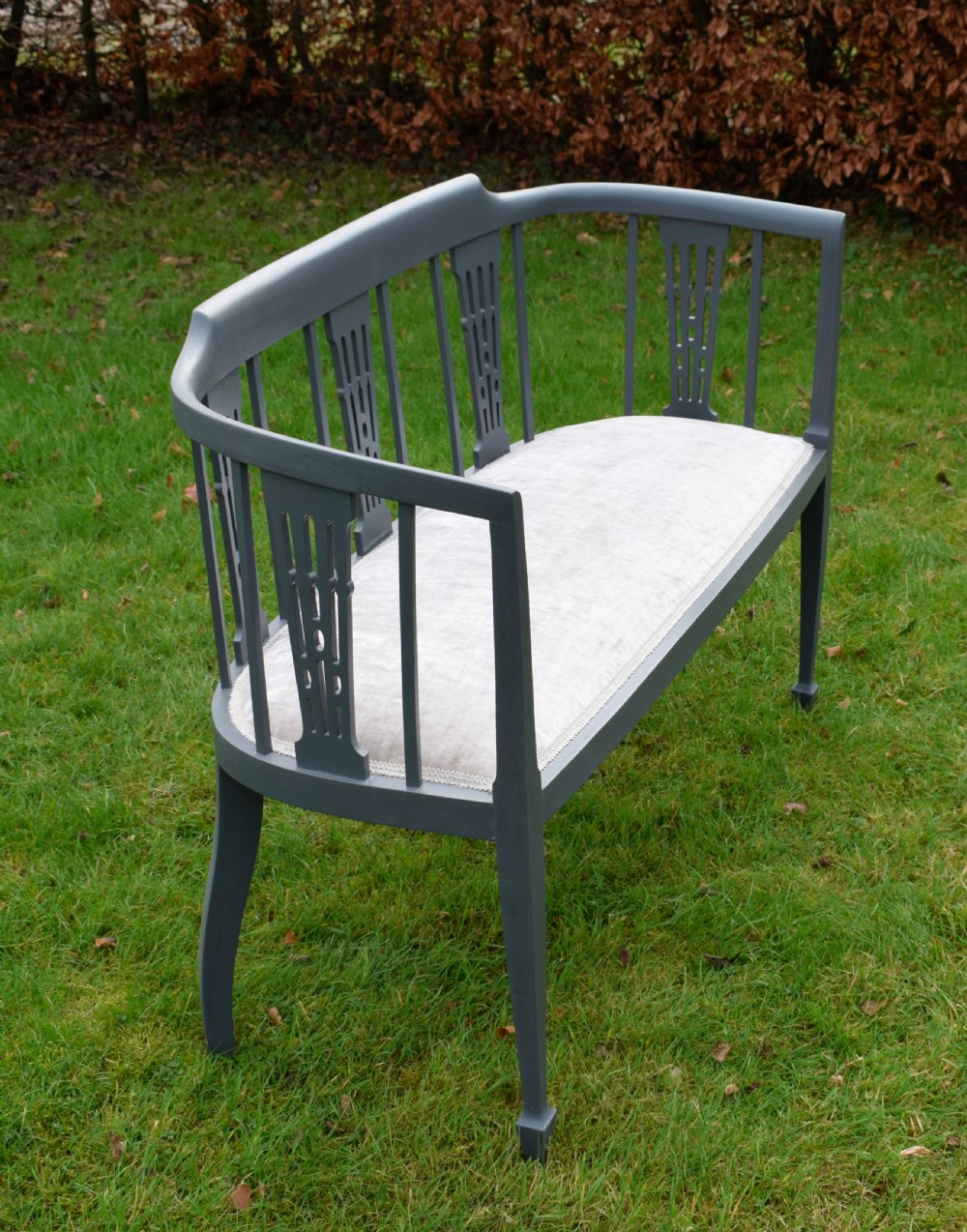 An Edwardian painted grey wooden settee featuring vertical spindles, pierced back splats, and a neutral beige velvet upholstered seat. View XIII