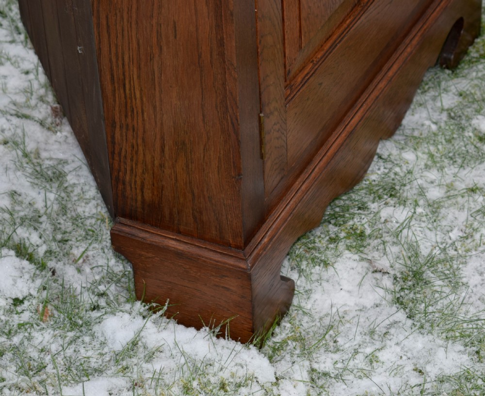 An early twentieth-century freestanding oak corner cabinet featuring an upper astragal glazed door and a lower solid panelled door on bracket feet. View XV