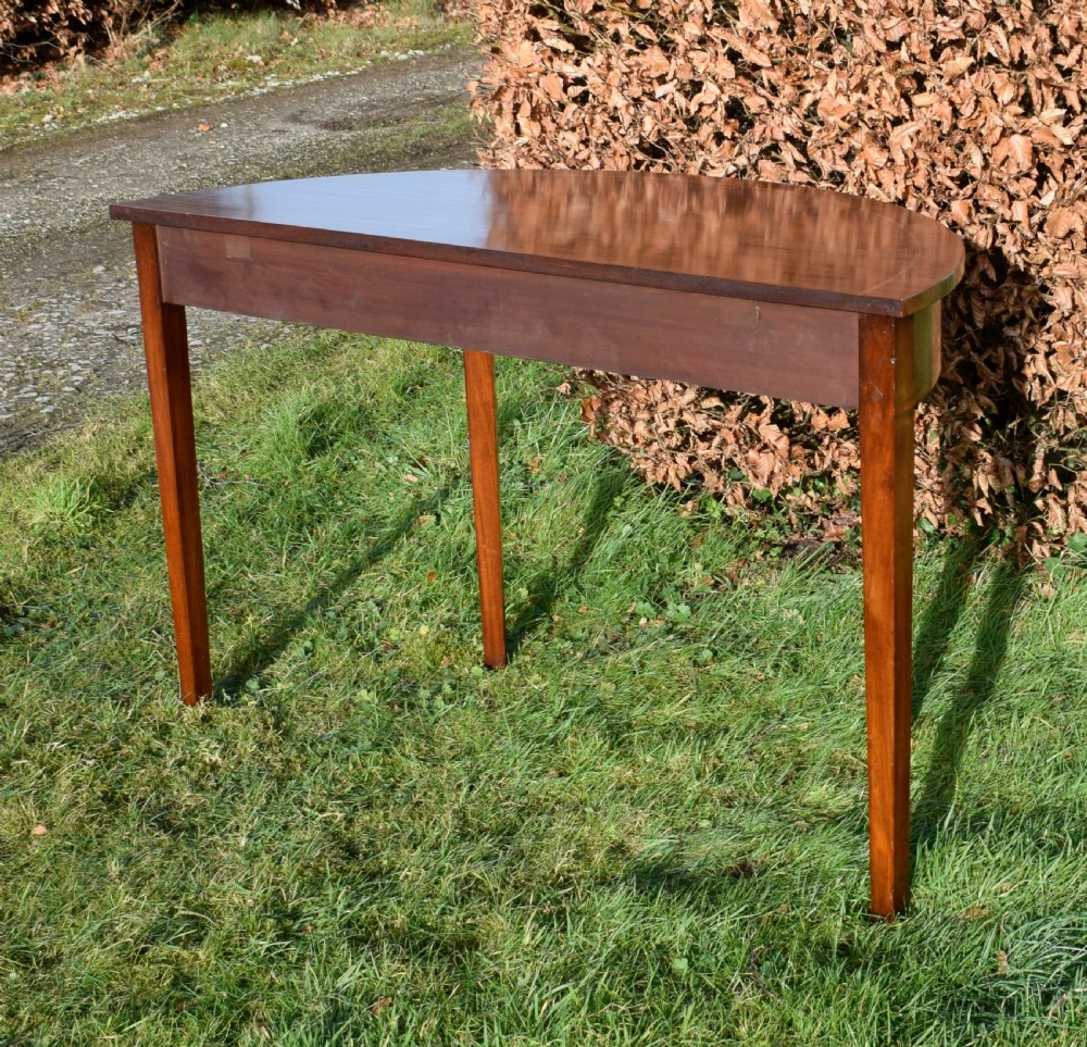 A Georgian mahogany demi-lune console table featuring a semi-circular top with string inlay and three tapered legs. View VIII
