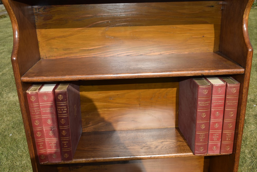 A tall early 20th-century open-front oak bookcase featuring four fixed shelves and a shaped top gallery. View VII