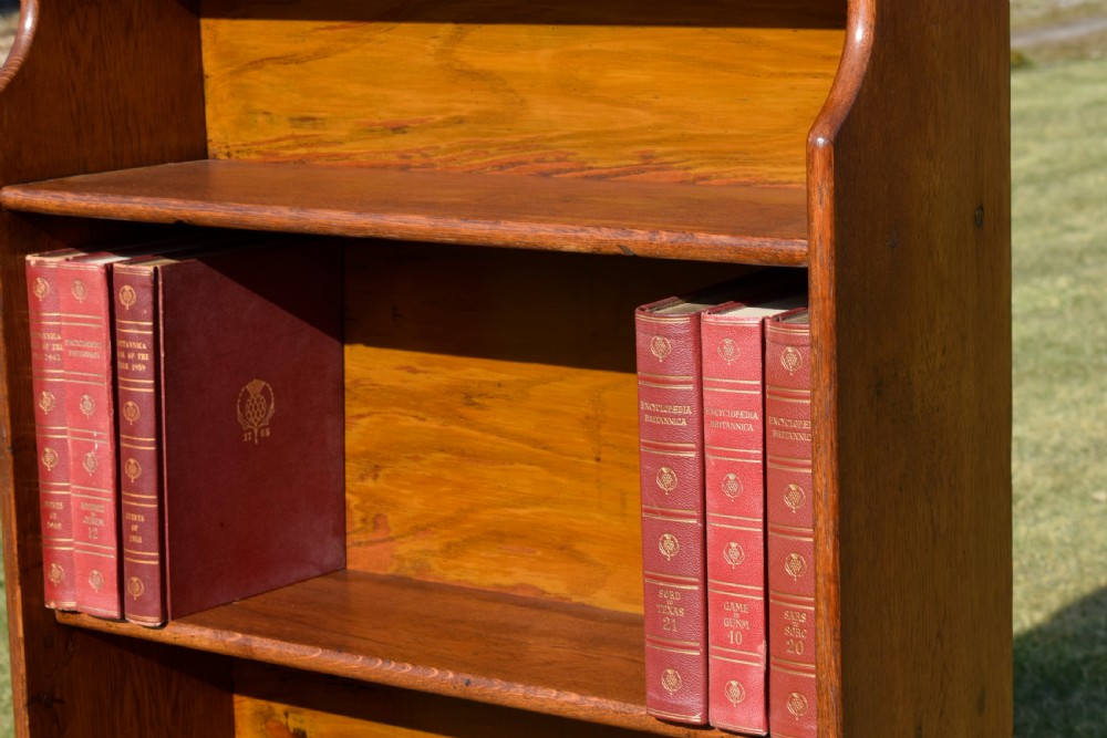 A tall early 20th-century open-front oak bookcase featuring four fixed shelves and a shaped top gallery. View XI