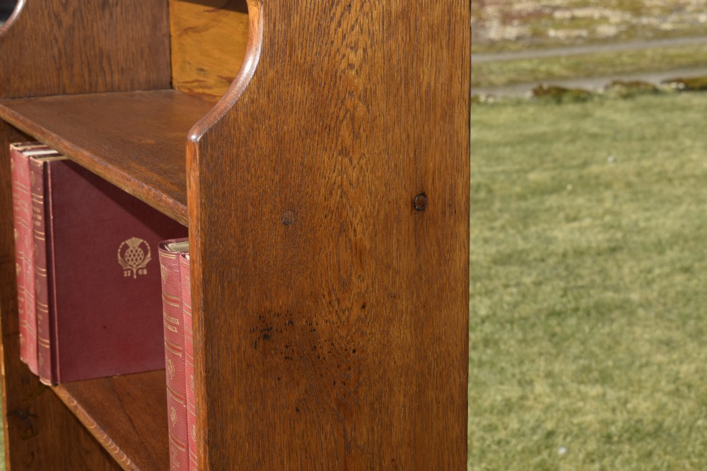 A tall early 20th-century open-front oak bookcase featuring four fixed shelves and a shaped top gallery. View XV