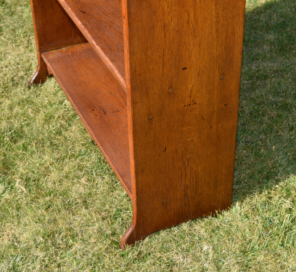 A tall early 20th-century open-front oak bookcase featuring four fixed shelves and a shaped top gallery. View XVI