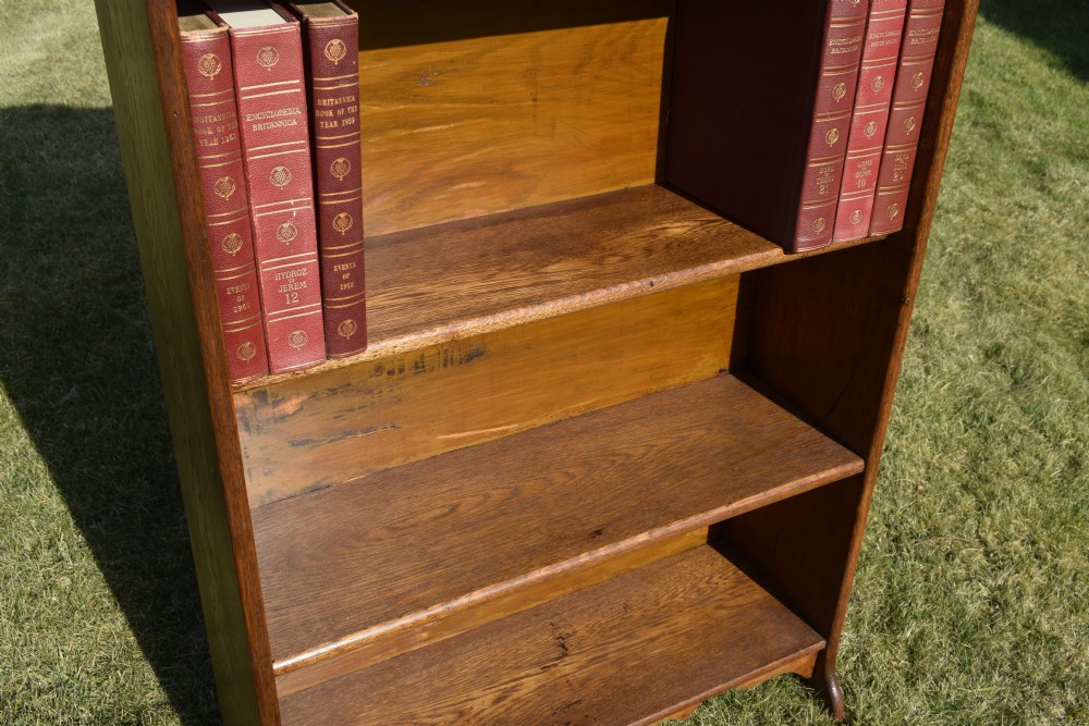 A tall early 20th-century open-front oak bookcase featuring four fixed shelves and a shaped top gallery. View XVIII