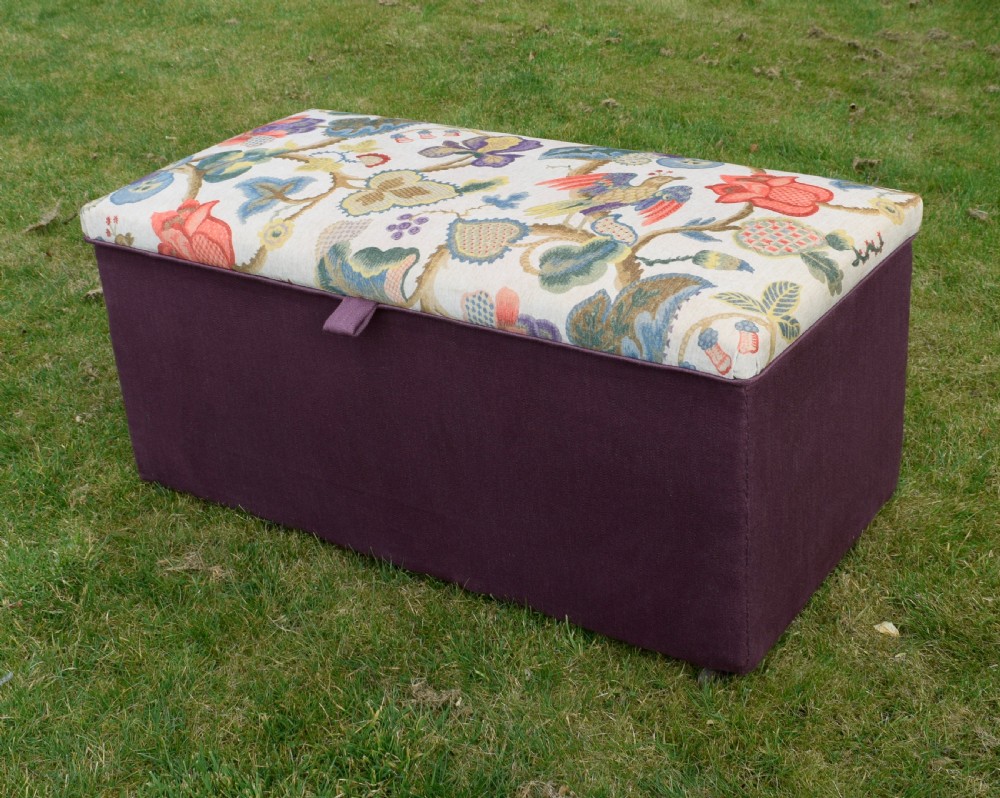 A rectangular Victorian upholstered storage ottoman featuring a deep purple base and a floral patterned fabric lid. View II
