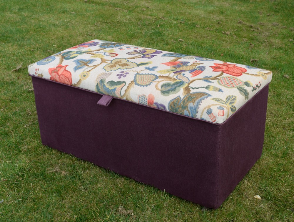 A rectangular Victorian upholstered storage ottoman featuring a deep purple base and a floral patterned fabric lid. View VI