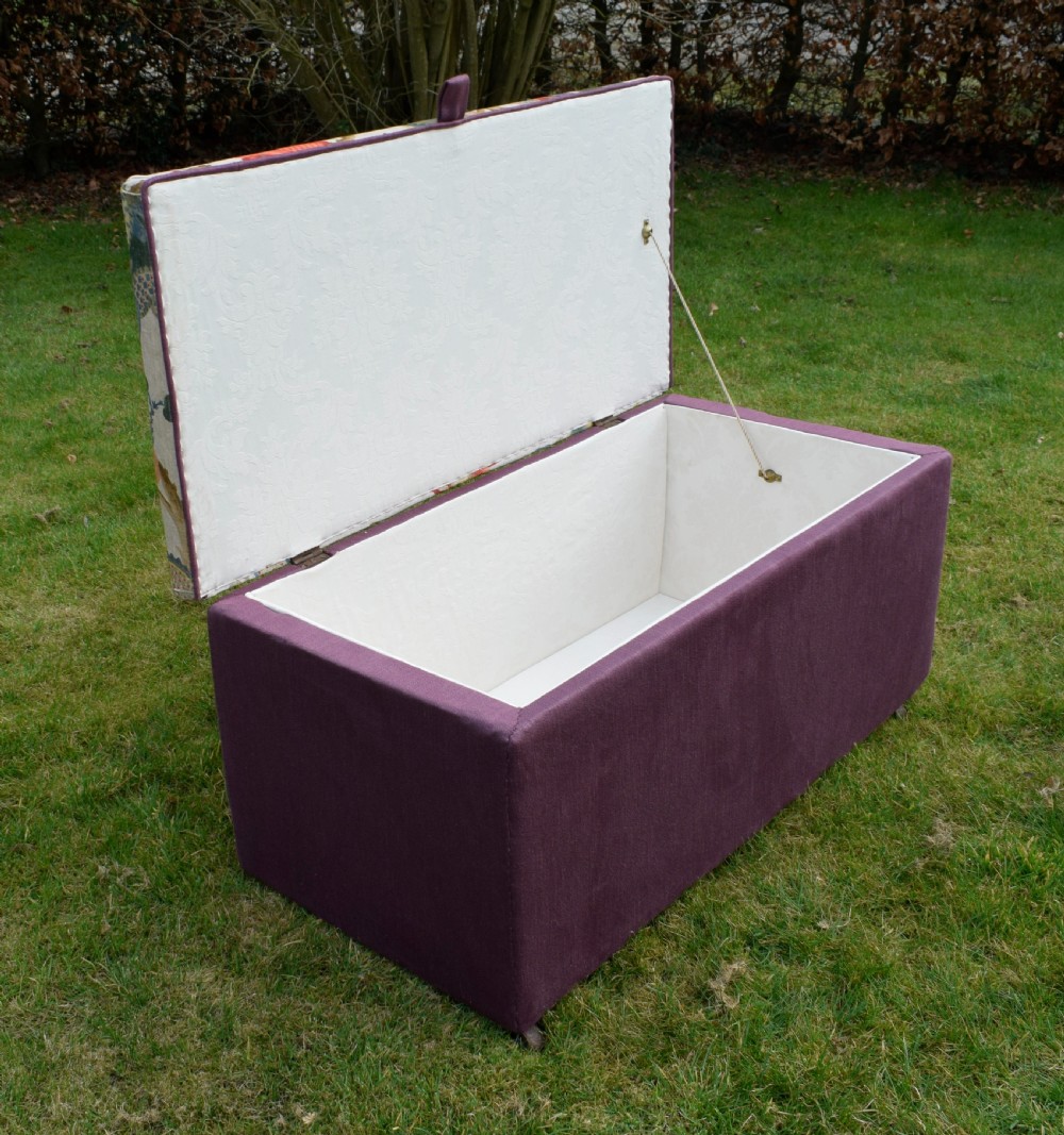 A rectangular Victorian upholstered storage ottoman featuring a deep purple base and a floral patterned fabric lid. View VIII
