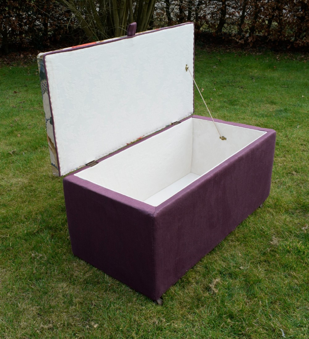 A rectangular Victorian upholstered storage ottoman featuring a deep purple base and a floral patterned fabric lid. View XIX