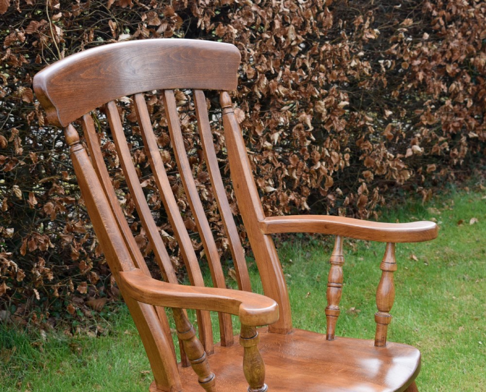 An early 20th-century warm brown wooden country kitchen armchair with vertical back spindles and turned legs. View VI