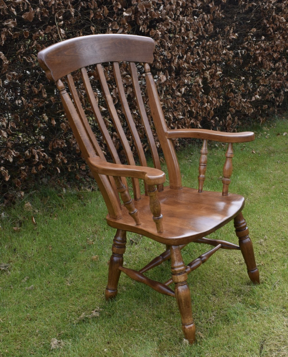 An early 20th-century warm brown wooden country kitchen armchair with vertical back spindles and turned legs. View VII