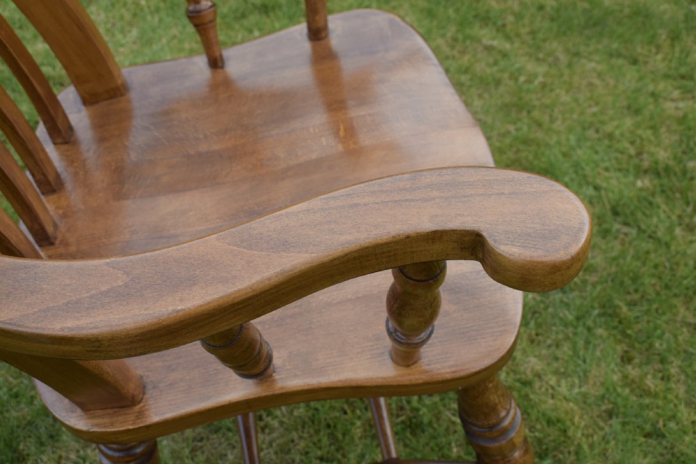 An early 20th-century warm brown wooden country kitchen armchair with vertical back spindles and turned legs. View XIX