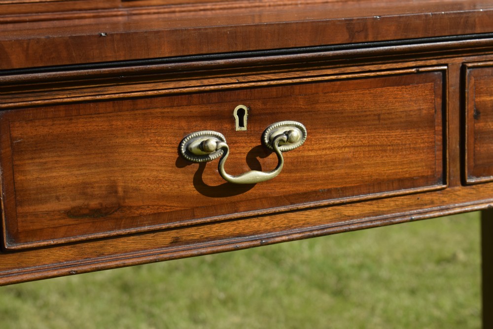 An Edwardian mahogany writing desk featuring a top superstructure with pigeonholes, cupboards, and small drawers above two frieze drawers on fluted tapered legs. View XXII