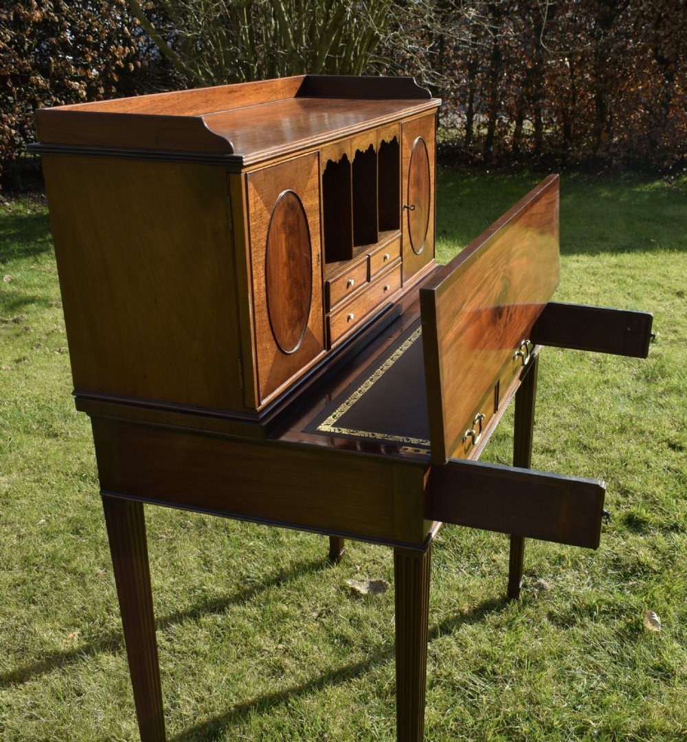An Edwardian mahogany writing desk featuring a top superstructure with pigeonholes, cupboards, and small drawers above two frieze drawers on fluted tapered legs. View XXX