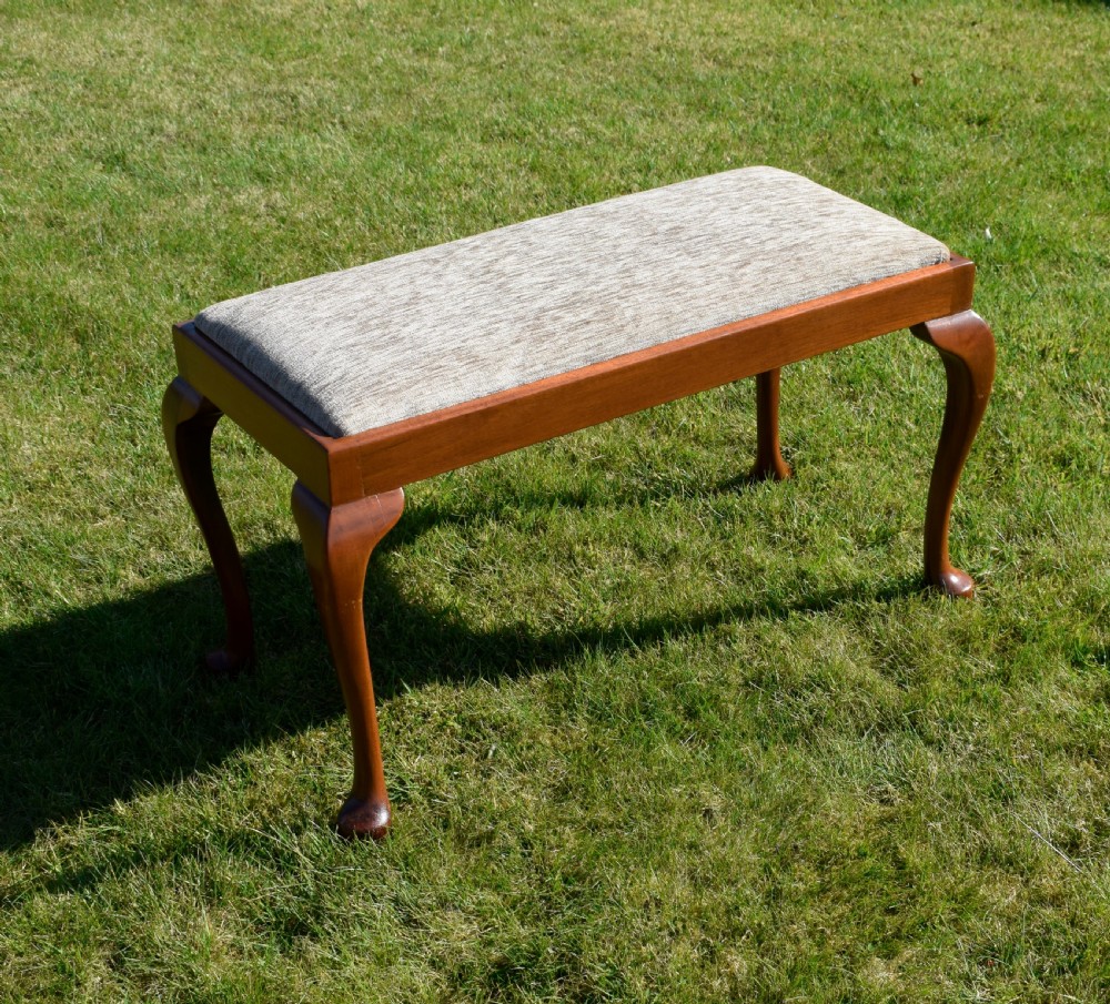 An early 20th-century duet stool with a woven fabric seat and warm brown mahogany cabriole legs. View III