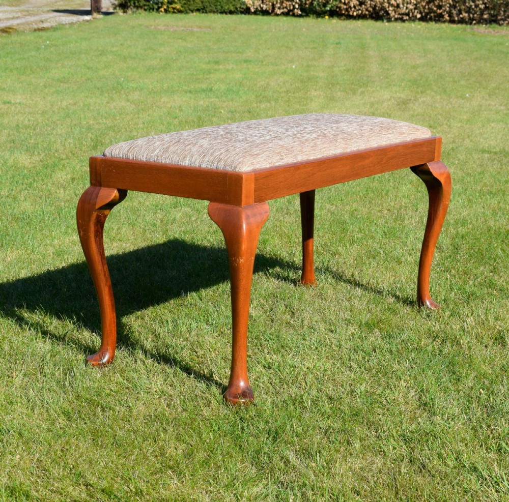 An early 20th-century duet stool with a woven fabric seat and warm brown mahogany cabriole legs. View VI