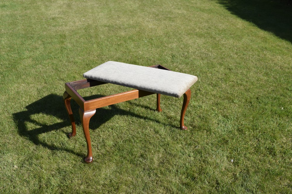 An early 20th-century duet stool with a woven fabric seat and warm brown mahogany cabriole legs. View VIII