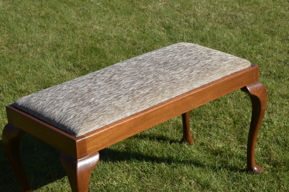 An early 20th-century duet stool with a woven fabric seat and warm brown mahogany cabriole legs. View IX