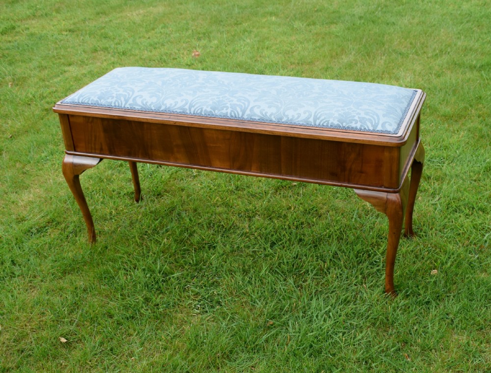 An elongated rectangular wooden duet piano stool featuring cabriole legs and a blue patterned damask upholstered seat trimmed with dark braid. View III
