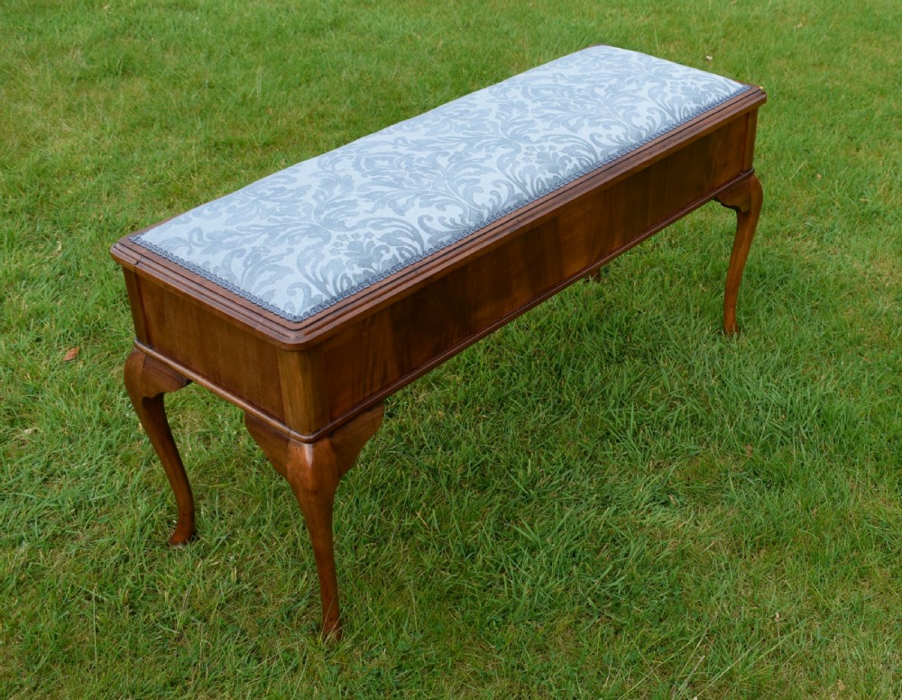 An elongated rectangular wooden duet piano stool featuring cabriole legs and a blue patterned damask upholstered seat trimmed with dark braid. View VII