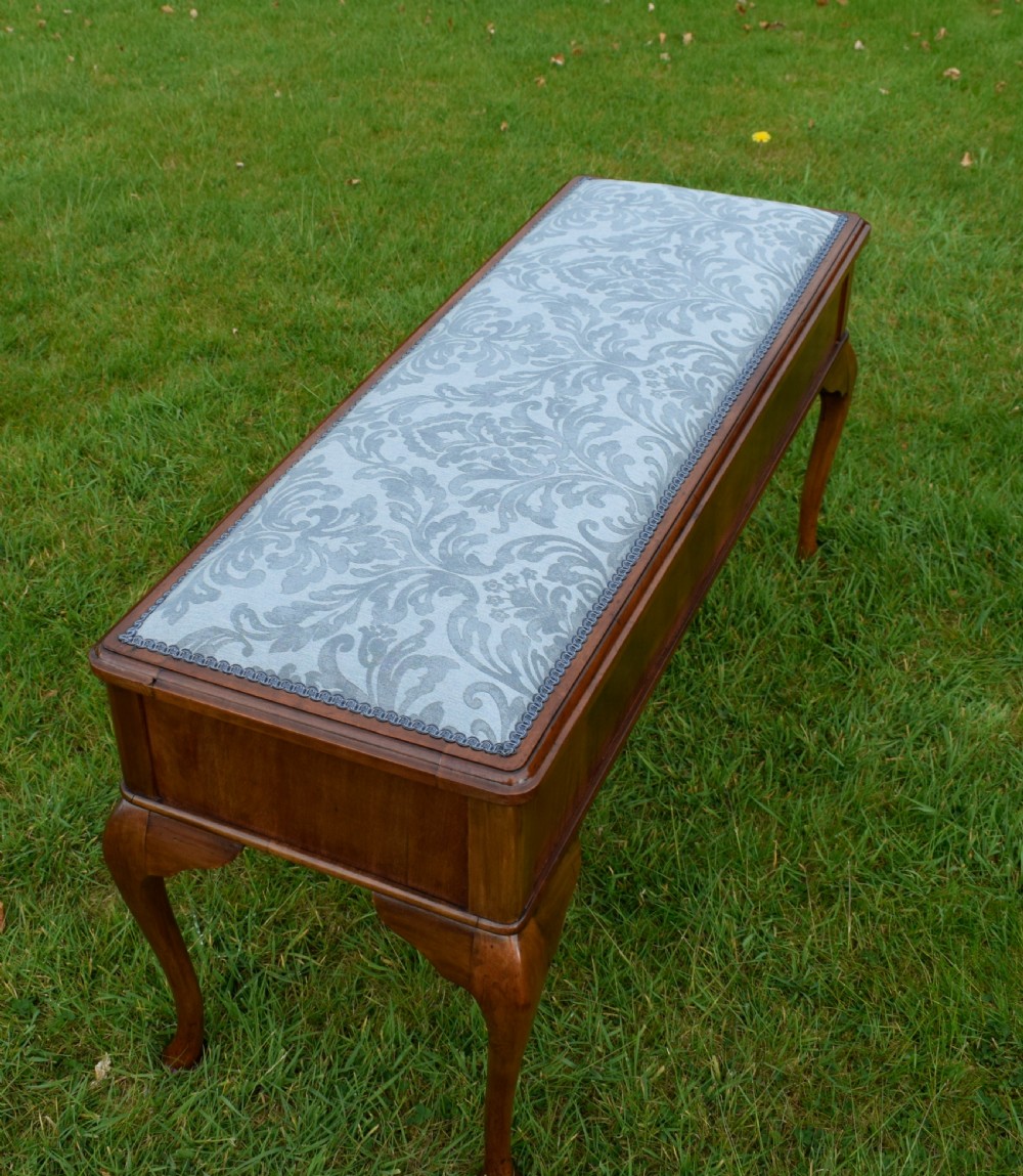 An elongated rectangular wooden duet piano stool featuring cabriole legs and a blue patterned damask upholstered seat trimmed with dark braid. View XII