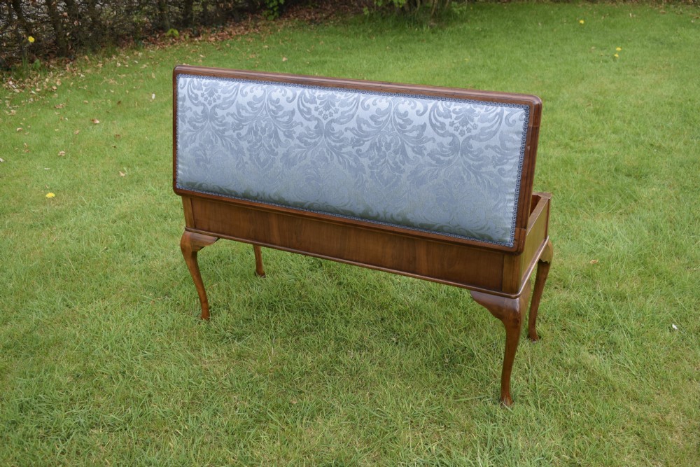 An elongated rectangular wooden duet piano stool featuring cabriole legs and a blue patterned damask upholstered seat trimmed with dark braid. View XIX
