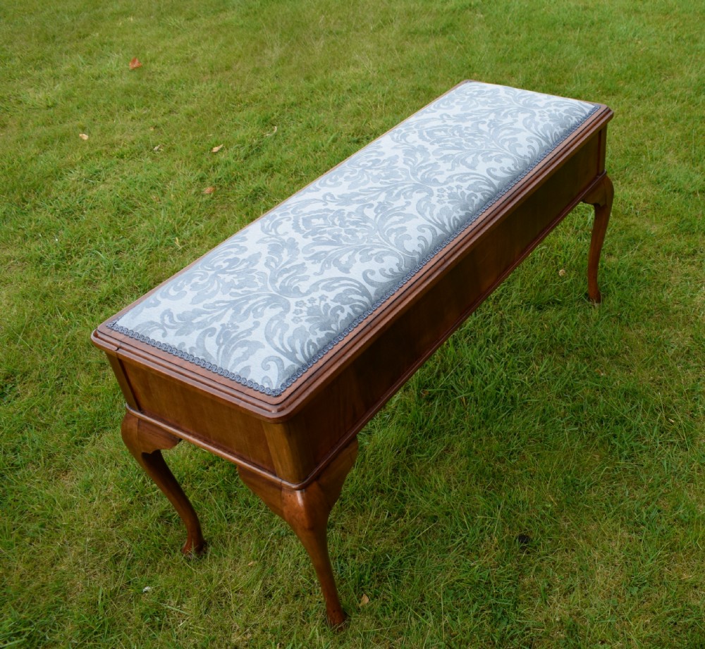 An elongated rectangular wooden duet piano stool featuring cabriole legs and a blue patterned damask upholstered seat trimmed with dark braid. View XXII