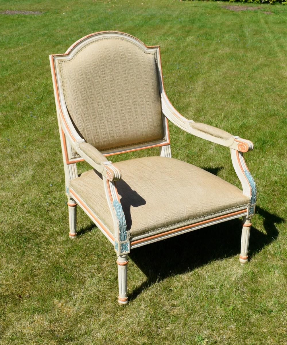 An early 20th-century French Louis XVI style fauteuil armchair featuring a painted off-white frame with fluted legs and beige herringbone fabric upholstery.
