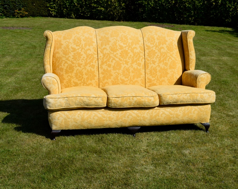 An early 20th-century Georgian style three-seater settee upholstered in yellow floral damask fabric with a serpentine crest back and scrolled arms. View III