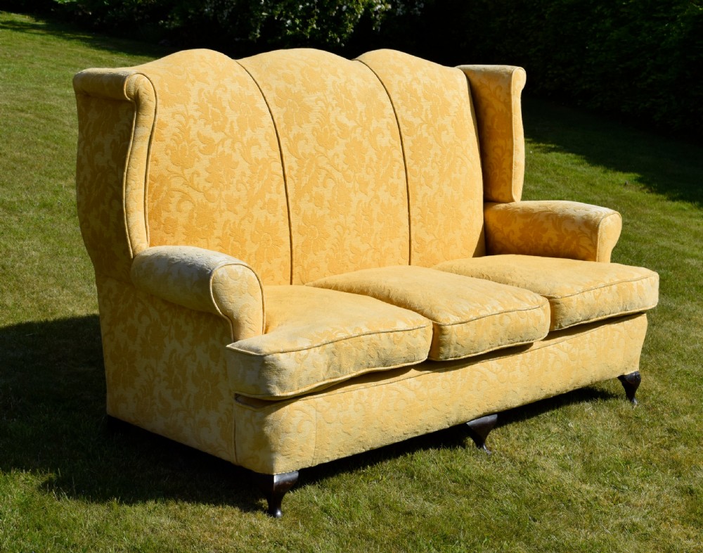 An early 20th-century Georgian style three-seater settee upholstered in yellow floral damask fabric with a serpentine crest back and scrolled arms. View VI
