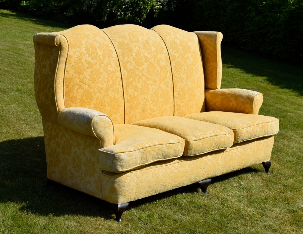 An early 20th-century Georgian style three-seater settee upholstered in yellow floral damask fabric with a serpentine crest back and scrolled arms. View VII