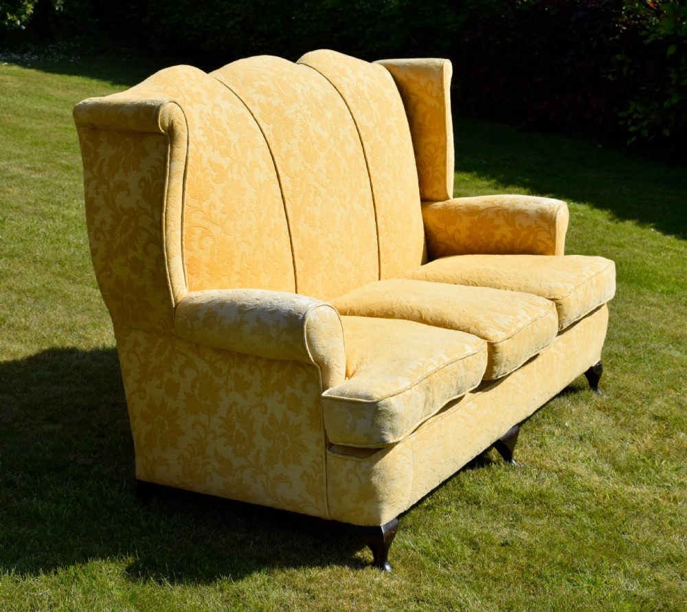 An early 20th-century Georgian style three-seater settee upholstered in yellow floral damask fabric with a serpentine crest back and scrolled arms. View VIII
