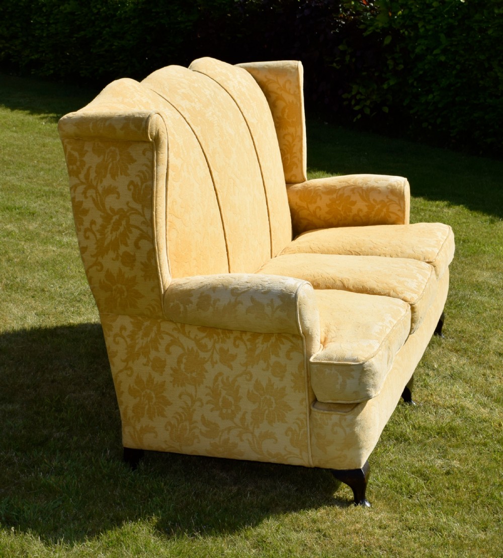 An early 20th-century Georgian style three-seater settee upholstered in yellow floral damask fabric with a serpentine crest back and scrolled arms. View IX