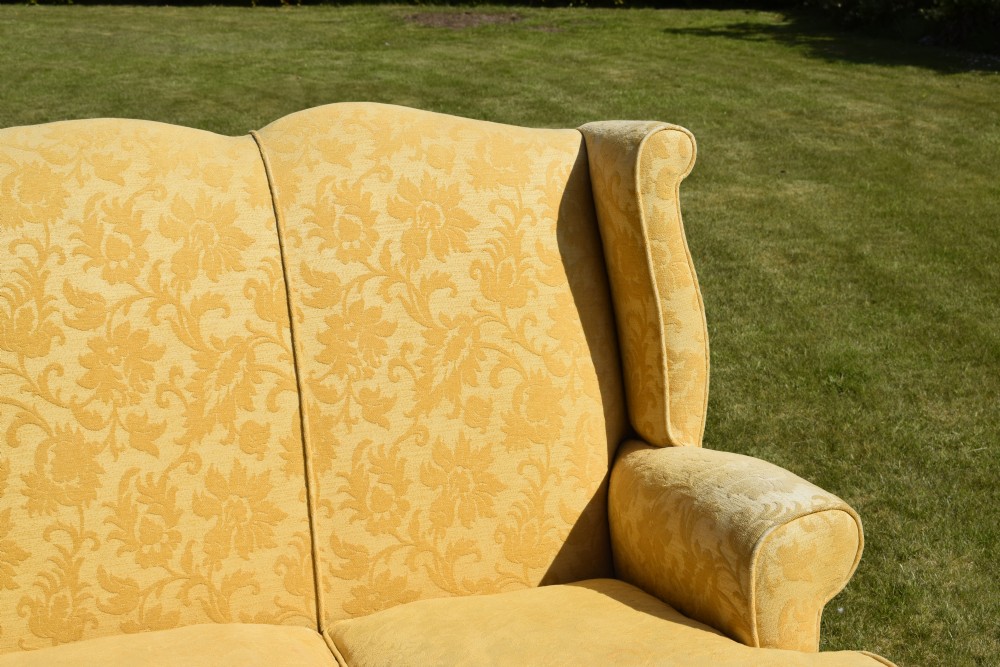 An early 20th-century Georgian style three-seater settee upholstered in yellow floral damask fabric with a serpentine crest back and scrolled arms. View XII